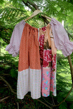Load image into Gallery viewer, Vintage pink patchwork  dress on a hanger smock top against a green leafy background, featuring upcycled and vintage heirloom fabrics. One size plus size smock top 