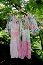 Load image into Gallery viewer, Vintage pink patchwork  dress on a hanger against a green leafy background, featuring upcycled and vintage heirloom fabrics. One size plus size smock top 