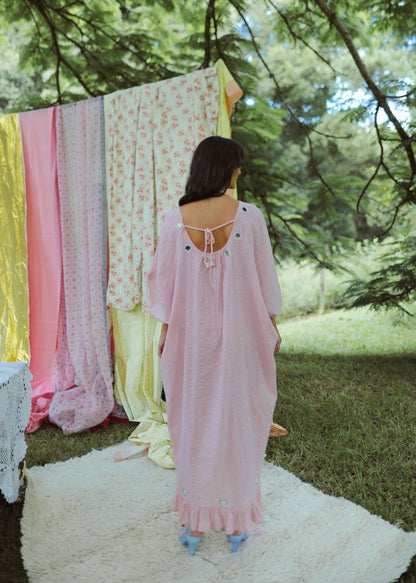 Dark haired woman in a one size, plus size, free size, pink dress with silver lurex strip and indian mirrorwork in an outdoor garden setting