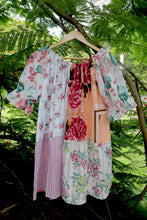 Load image into Gallery viewer, Vintage pink patchwork  dress on a hanger against a green leafy background, featuring upcycled and vintage heirloom fabrics. One size plus size smock top 
