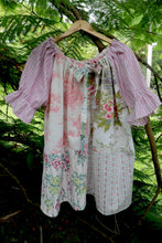 Load image into Gallery viewer, Vintage pink patchwork  dress on a hanger against a green leafy background, featuring upcycled and vintage heirloom fabrics. One size plus size smock top 