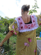 Load image into Gallery viewer, Person wearing a colorful dress with heart patterns in an outdoor setting