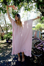 Load image into Gallery viewer, Woman in a one size, plus size, free size, pink dress with silver lurex strip and indian mirrorwork holding flowers in an outdoor , seaside setting