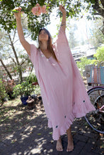 Load image into Gallery viewer, Woman in a one size, plus size, free size, pink dress with silver lurex strip and indian mirrorwork holding flowers in an outdoor , seaside setting