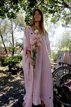 Load image into Gallery viewer, Woman in a one size, plus size, free size, pink dress with silver lurex strip and indian mirrorwork holding flowers in an outdoor , seaside setting