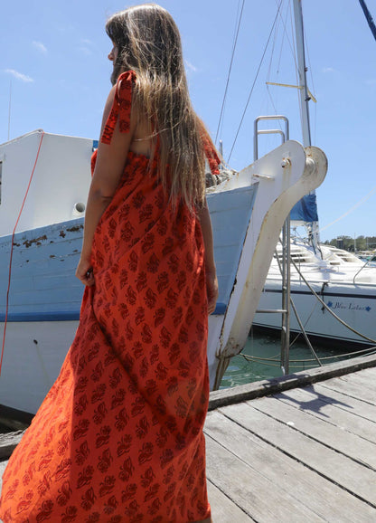 Woman in a plus size, one size, bohemian orange dress standing on a dock with boats in the background, black friday sale, Christmas Gifts