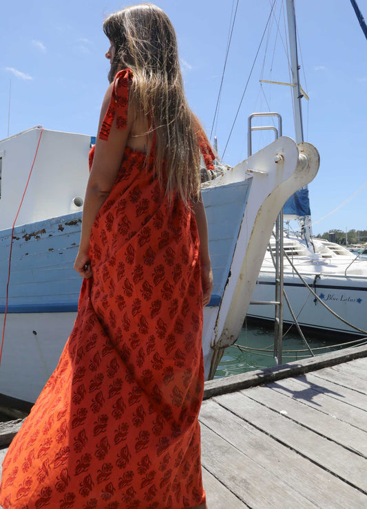 Woman in a plus size, one size, bohemian orange dress standing on a dock with boats in the background, black friday sale, Christmas Gifts
