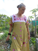 Load image into Gallery viewer, Woman wearing a yellow checkered dress with pink heart applique patterns outdoors.