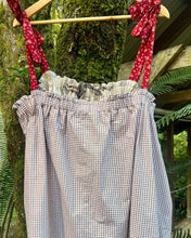 Load image into Gallery viewer, Brown gingham dress hanging on a beautiful tree with red rfloral ties against a natural background