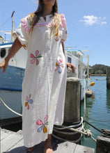 Load image into Gallery viewer, Person wearing a one size, plus size, bohemian white dress with colourful flower applique standing on a boat docked at a pier. Great Christmas Dress and black friday sale