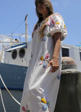 Load image into Gallery viewer, Person wearing a one size, plus size, bohemian white dress with colourful flower applique standing on a boat docked at a pier. Great Christmas Fashion Dress and black friday sale