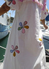Load image into Gallery viewer, Person wearing a one size, plus size, bohemian white dress with colourful flower applique standing on a boat docked at a pier. Great Christmas Fashion Dress and black friday sale